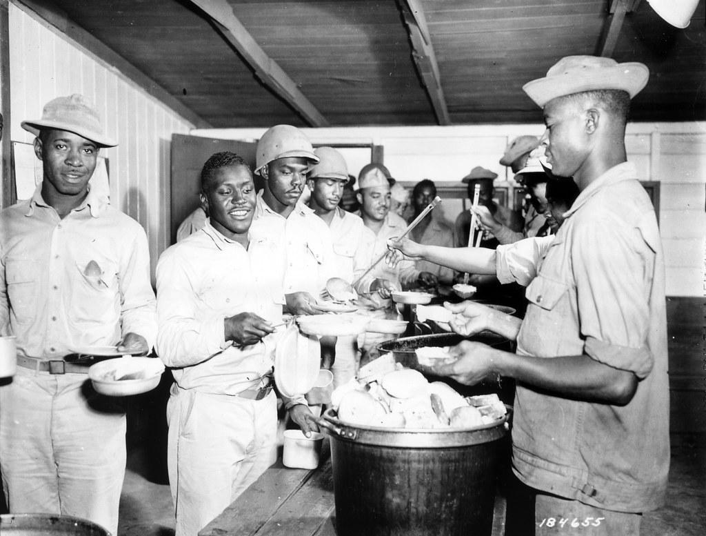 Historical image showing It's chow time for the 903rd Air Base Security Battalion. of Black American soldiers during WWII