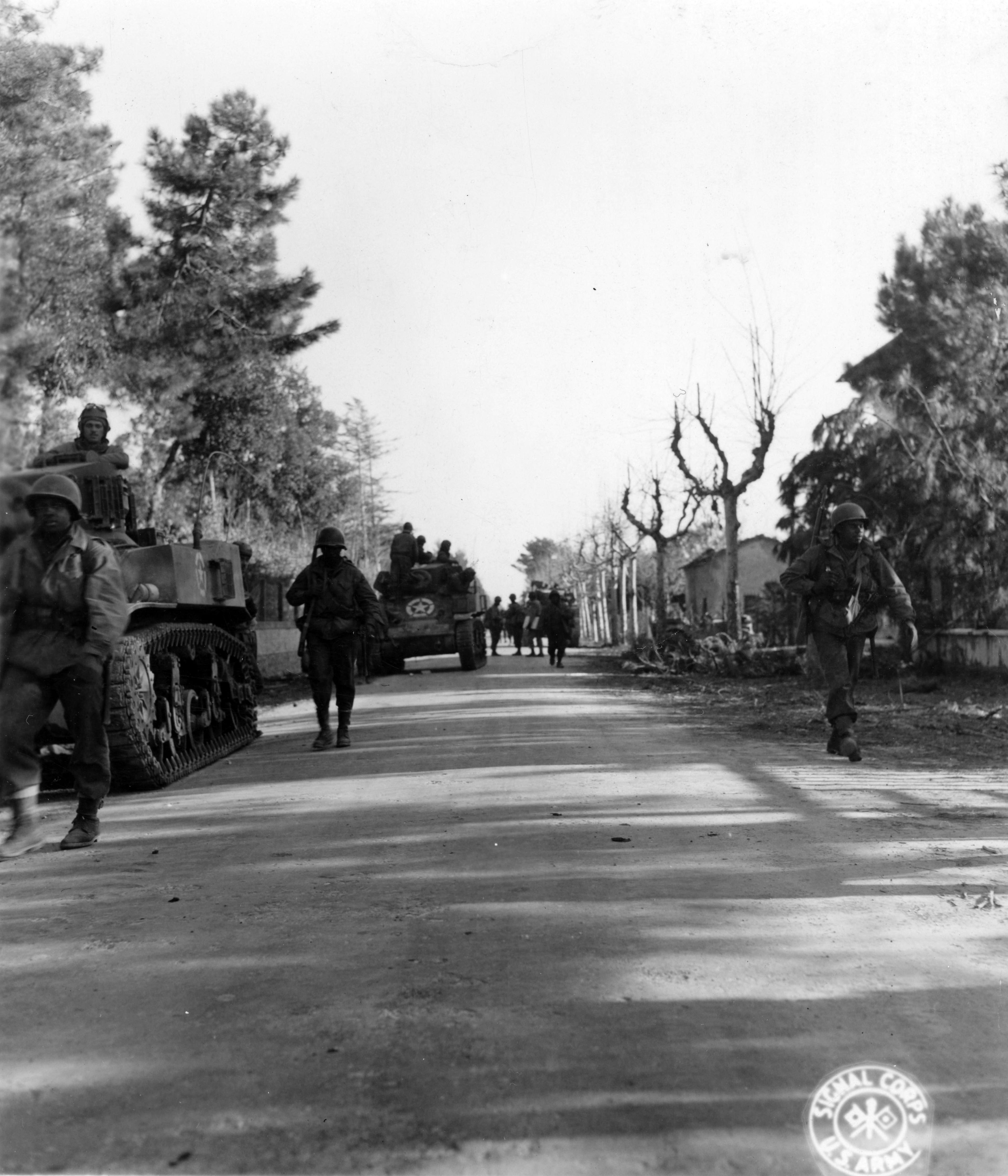 Historical image showing 92nd. Division offensive. Men of 370th Inf. Regt. dismounted from the tanks used to carry them to vicinity of Cinquale Canal, move away from tanks. of Black American soldiers during WWII