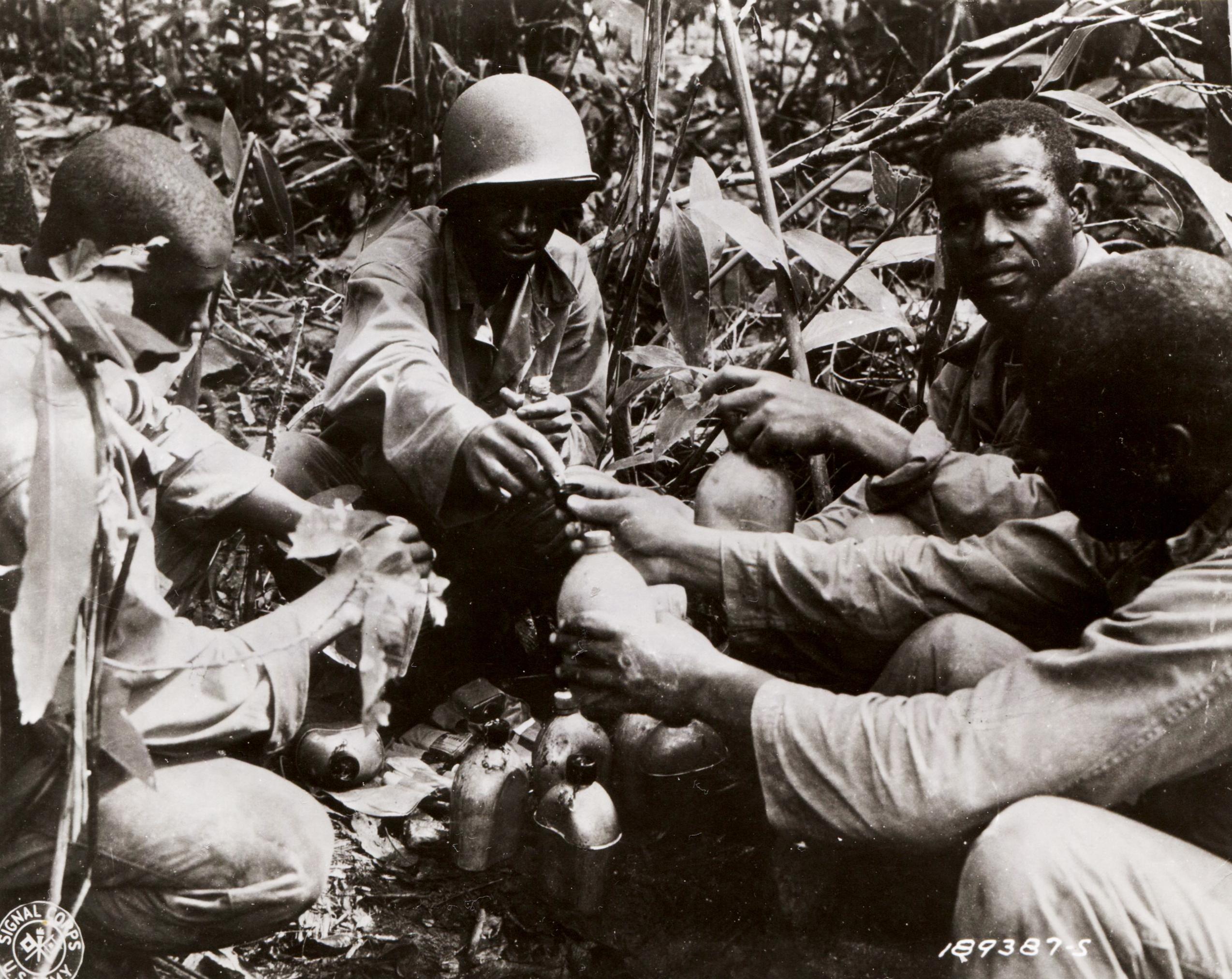 Historical image showing 93rd Infantry Division soldiers purify their drinking water of Black American soldiers during WWII