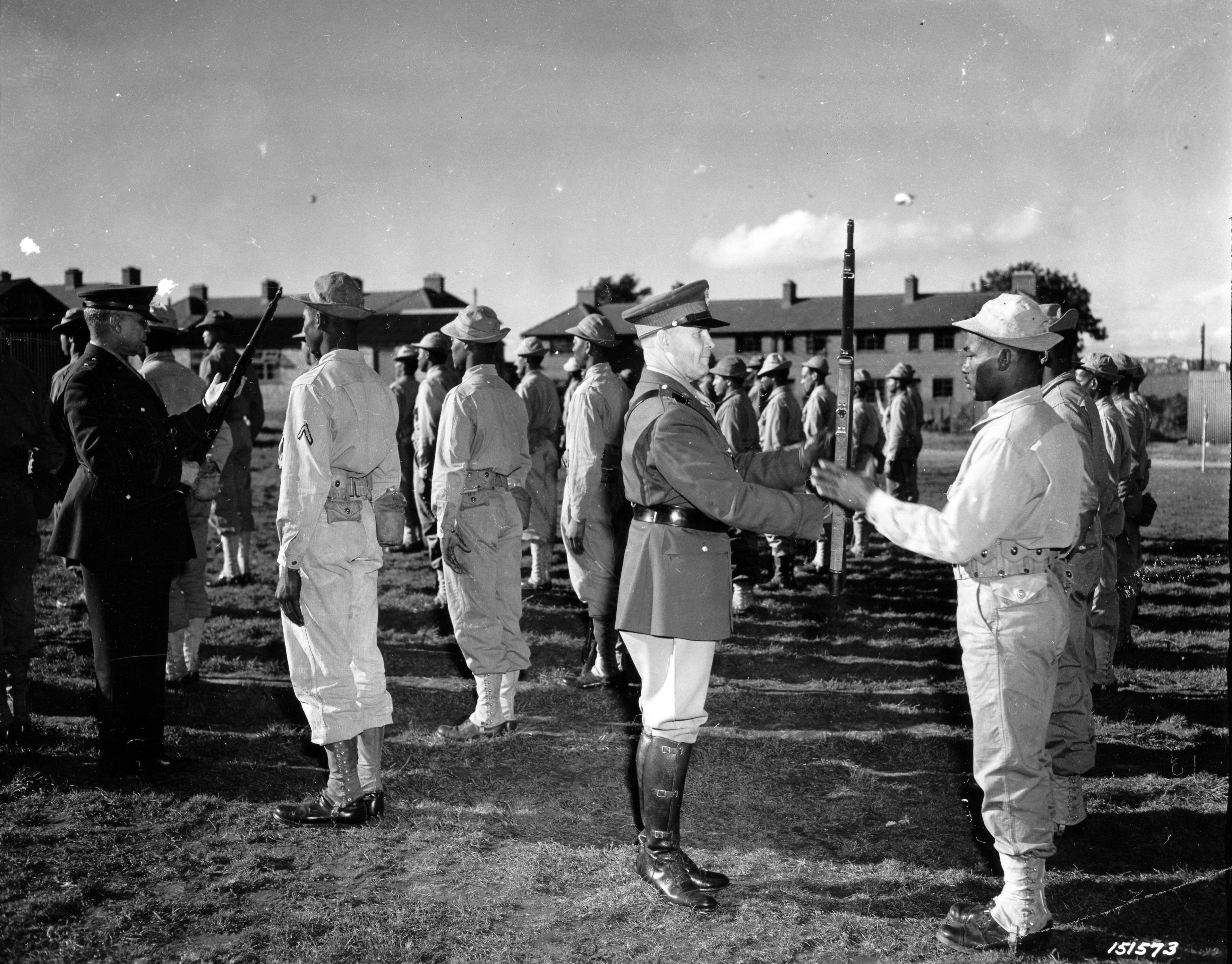 Historical image showing Brig. General Benjamin O. Davis, left, and Maj. General John C.H. Lee inspect troops during a tour of Black soldiers somewhere in England. of Black American soldiers during WWII